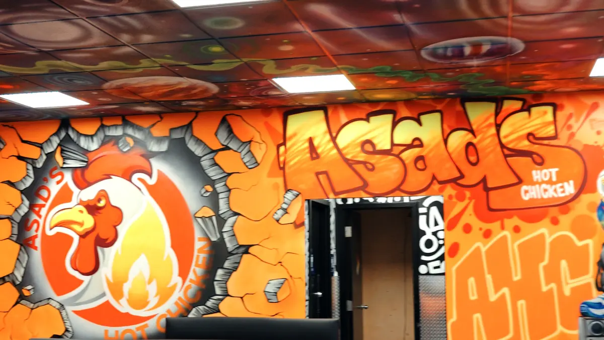 Inside Asad's Hot Chicken Vineland: orange booths and Asad's graffiti mural