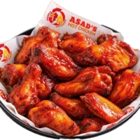 Bowl of sauced chicken wings on Asad's Hot Chicken branded paper
